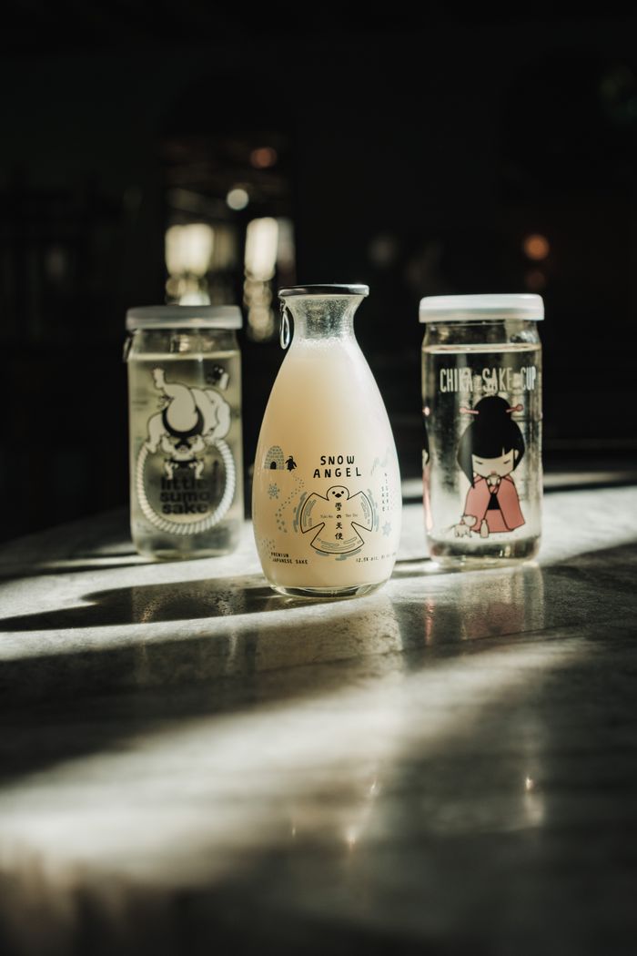 The Art of Drawing Readers In: Your attractive post title goes here A creative still life of Japanese nigori sake jars with unique, artistic designs under soft lighting.